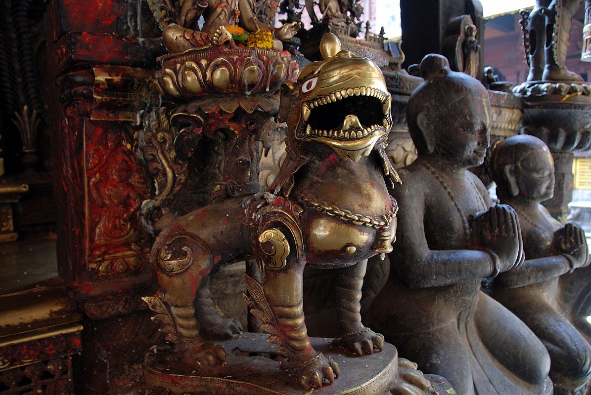 Kathmandu Patan Golden Temple 30 Statue Of Snow Lion Close Up And Two Kneeling Figures Outside Entrance Door To The Swayambhu Chaitya 